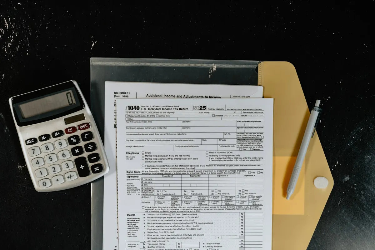 Calculadora y formularios fiscales sobre una superficie oscura