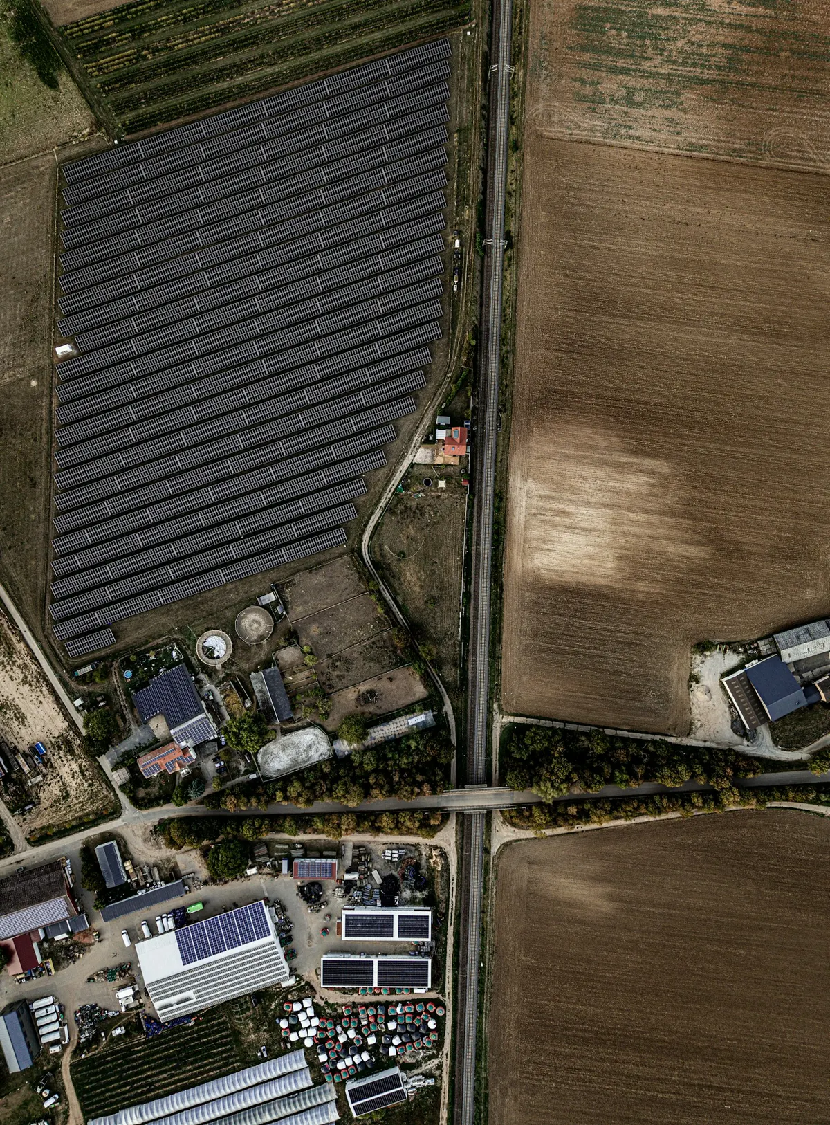Vista aerea de una planta solar junto a una via de tren