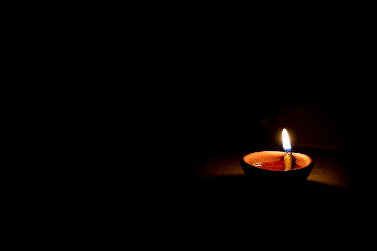 Una vela encendida en la oscuridad durante un apagon