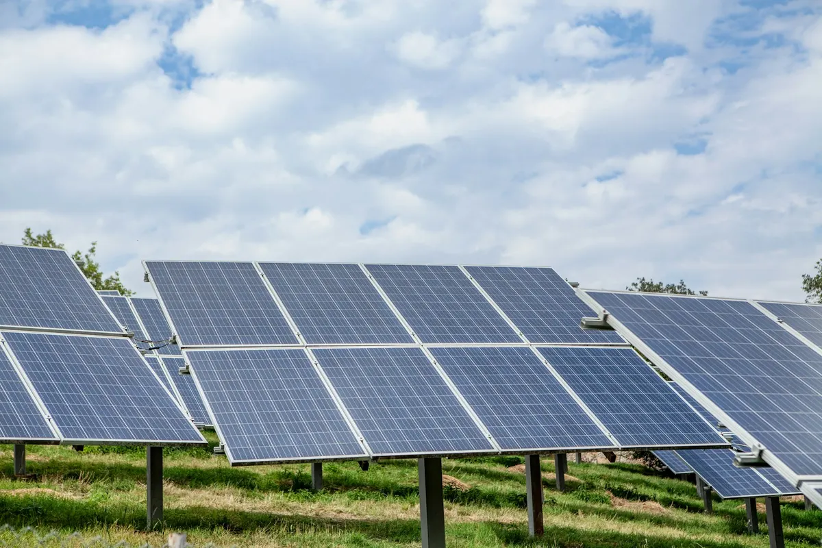 Paneles solares en un campo bajo un cielo nublado